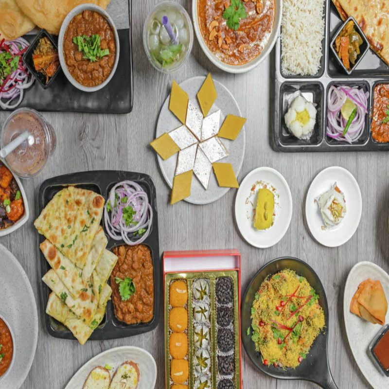 Table full of popular Indian snacks at BarShala, the top restaurant for Indian snacks in Hamilton, featuring samosas, pav bhaji, chaat, and more.