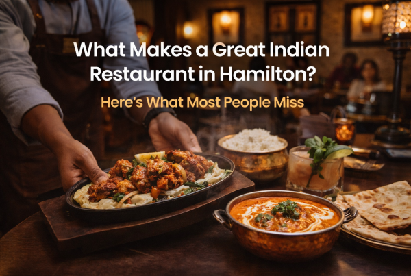 Warm and inviting Indian Restaurant in Hamilton serving butter chicken, naan, rice, and a sizzling platter, showcasing authentic Indian cuisine and a premium Indian dining experience.